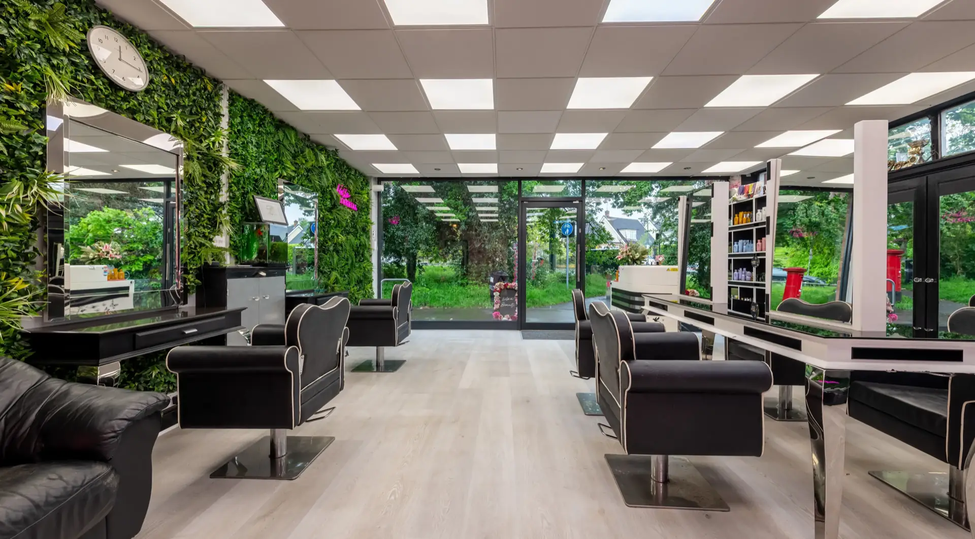 Hallie's Beauty salon interior in Amersham — styling chairs, green feature wall and natural light